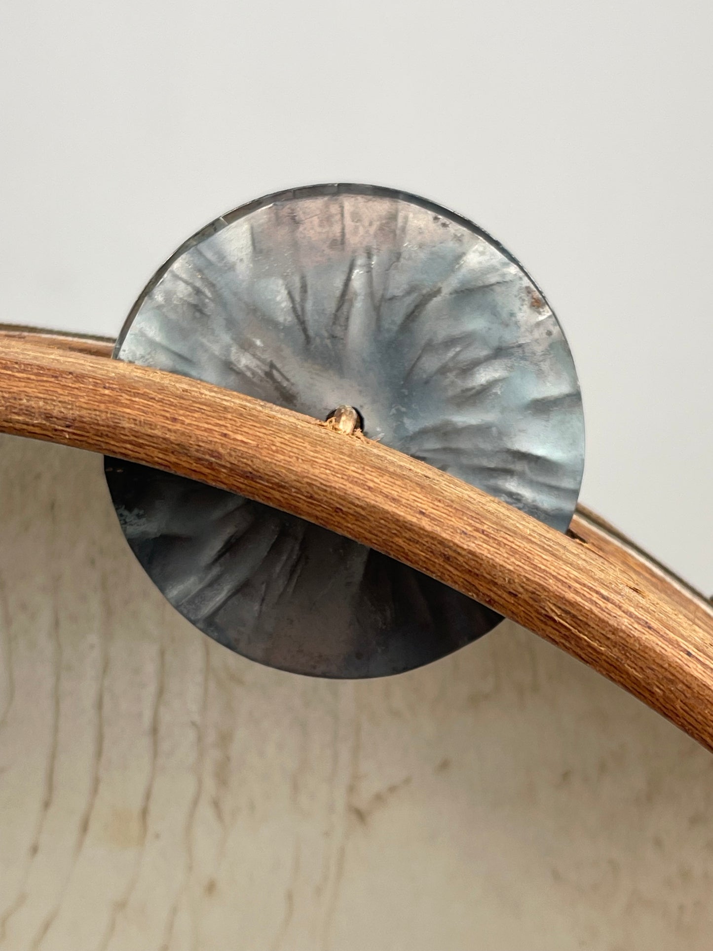 Close-up of hand-hammered tin jingles on mahogany frame