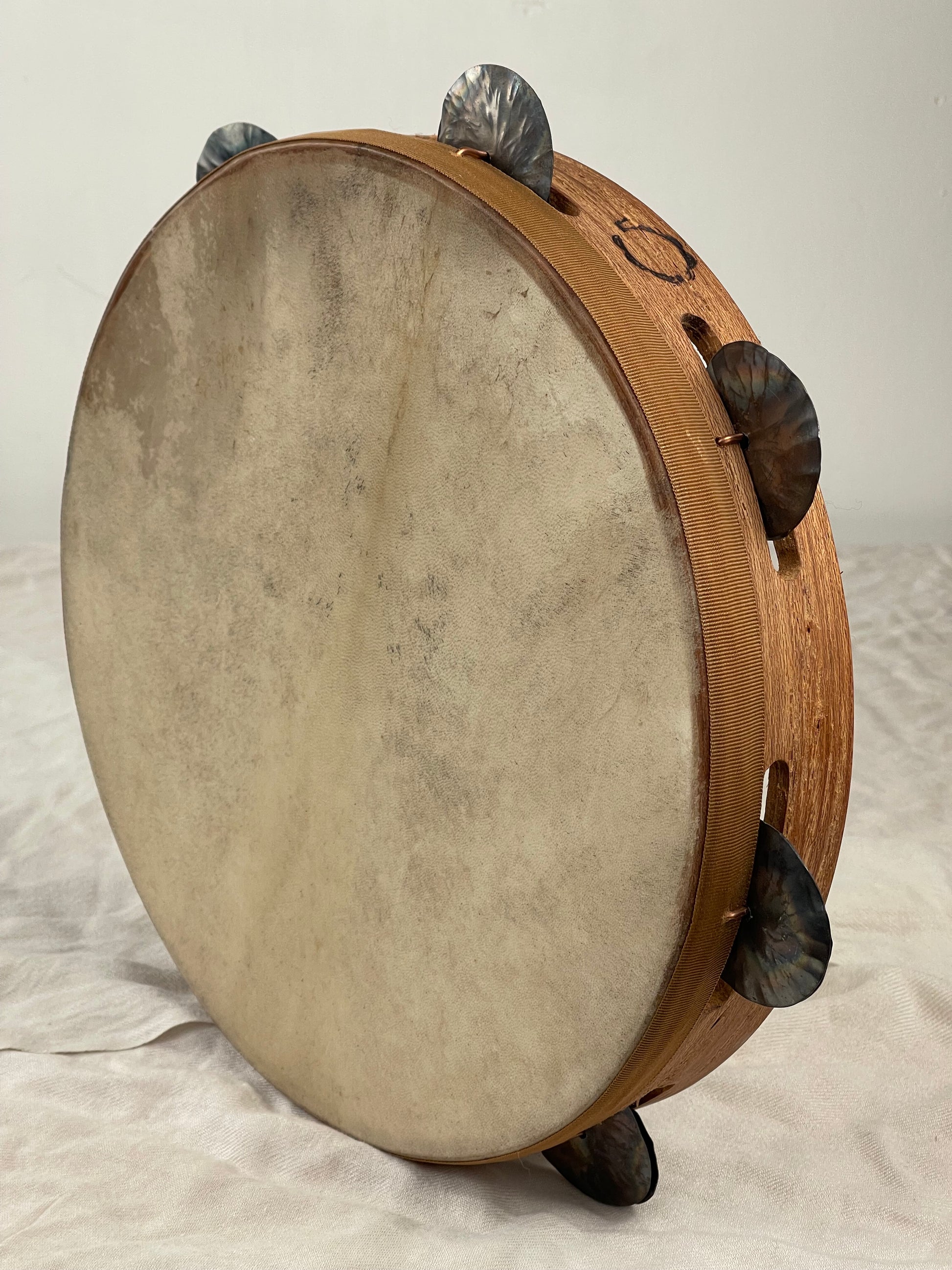 Front view of 30 cm traditional Calabrian tambourine with red goatskin head and tin jingles