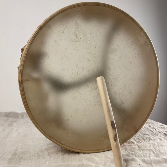 Olive wood beater resting on drum