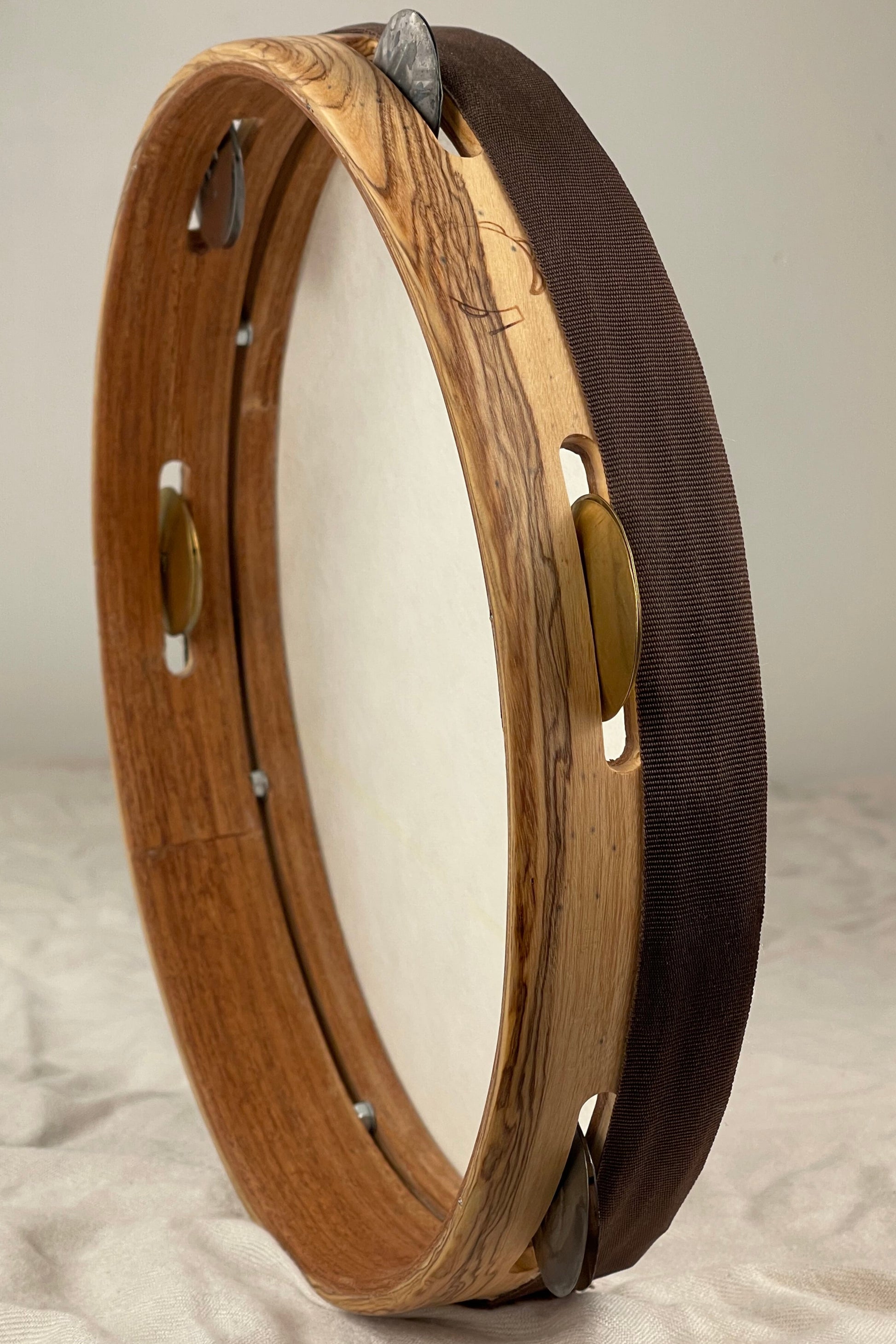 Side view of modern tamburello showing contrasting olive exterior and mahogany core