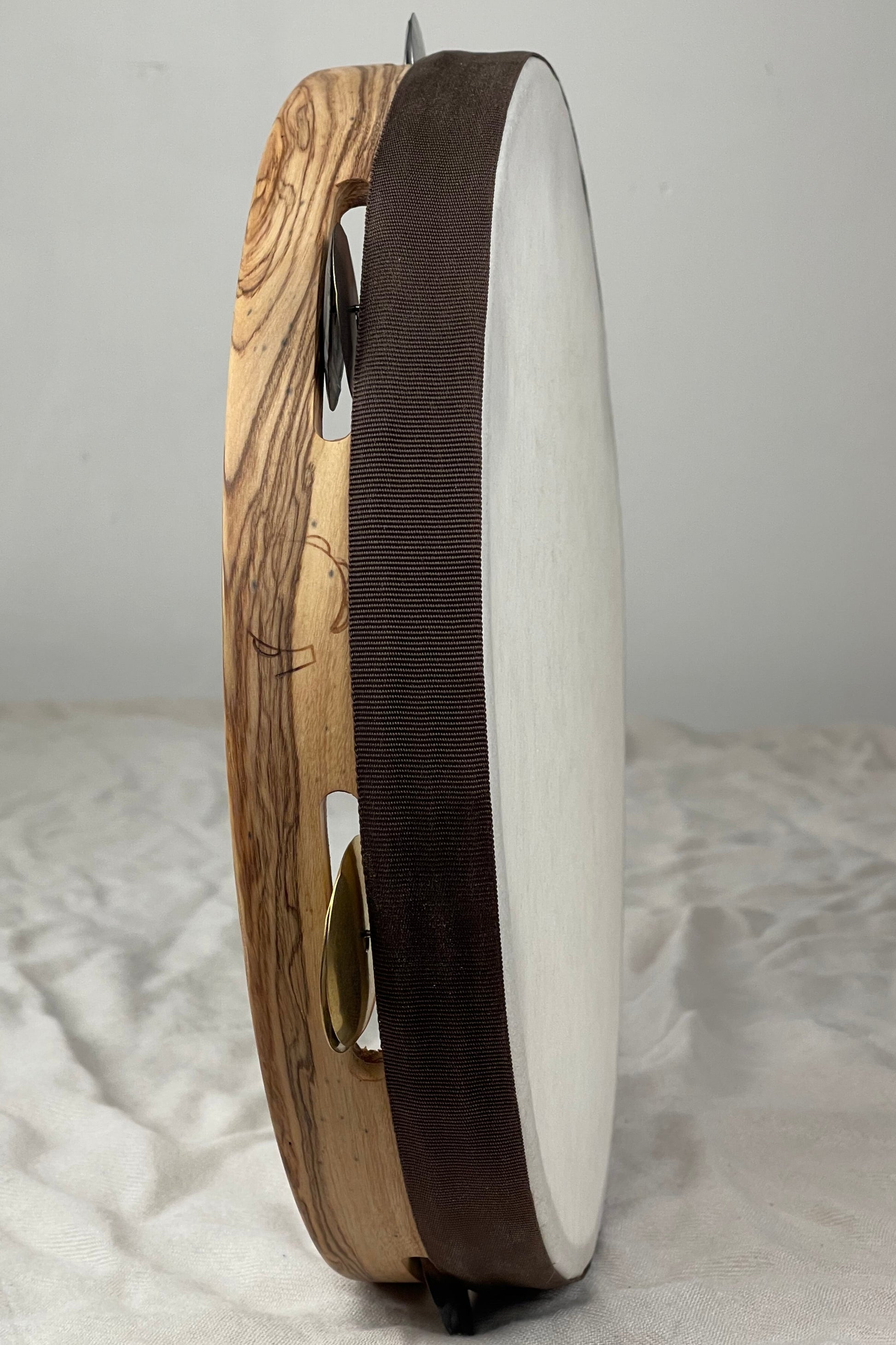 Side view of modern tamburello showing contrasting olive exterior and mahogany core