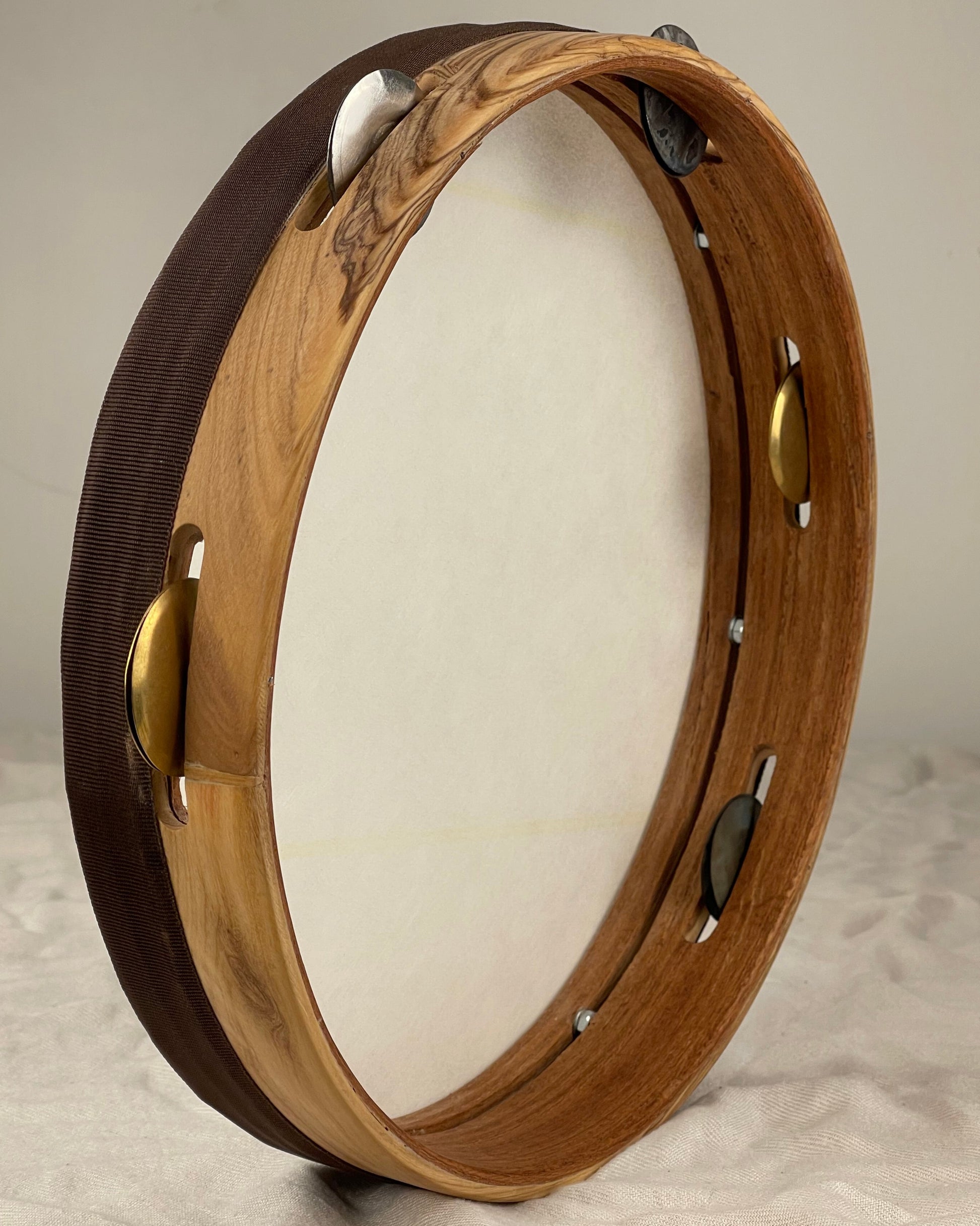 Side view of modern tamburello showing contrasting olive exterior and mahogany core