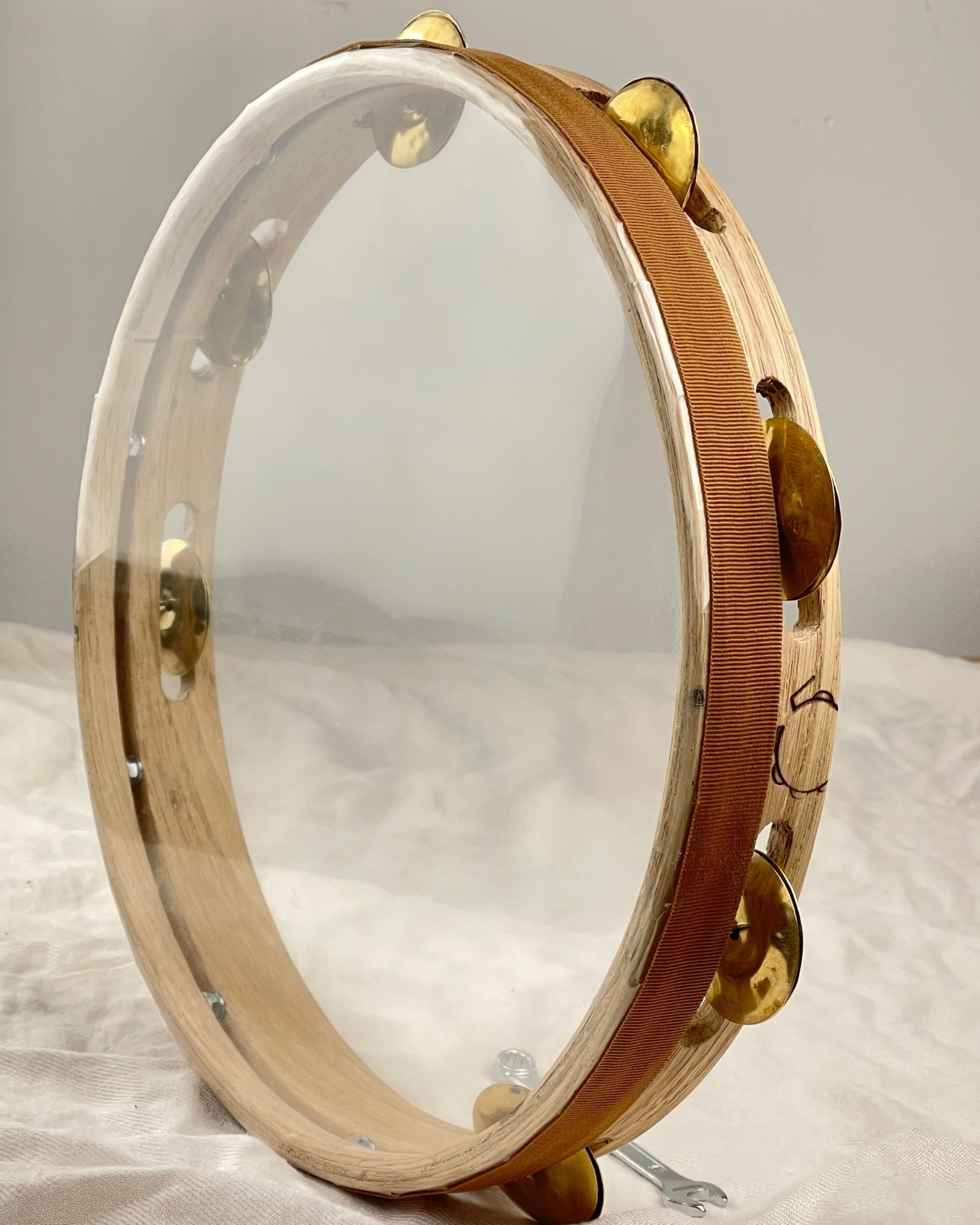 Close-up of hand-hammered 4.5 cm brass jingles on the Maestrale tamburello